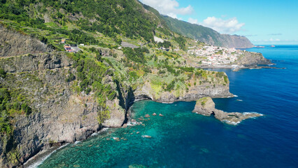 Obraz premium Beautiful wild coast scenery view with Bridal Veil Falls (Veu da noiva) at Ponta do Poiso in Madeira Island. Aerial view