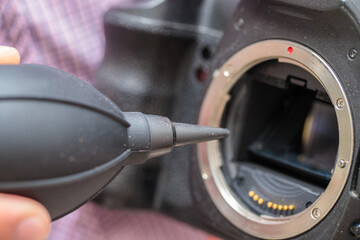blowing dust off the camera matrix using a special blower. close-up.
