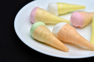 Marshmallow in the form of a sundae on a white plate. Colorful ice cream.