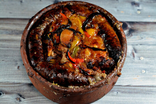 Traditional Egyptian mixture of lamb meat, sausage mumbar intestines filled with rice, kawareh trotters cow feet, pieces of cooked kidneys, hearts and testicles in a pottery casserole cooked in oven