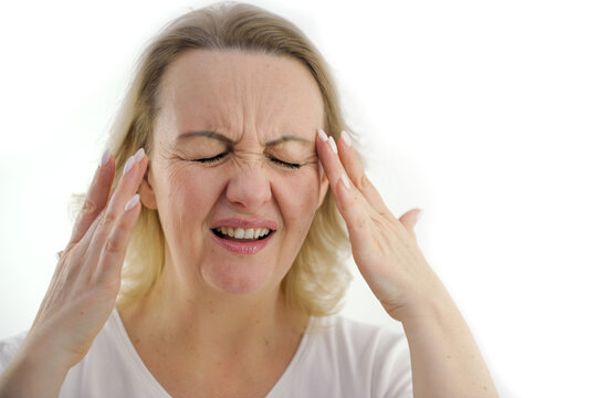 Old woman with a headache holds her hands to her temples Attractive woman having a headache on white background. High quality photo