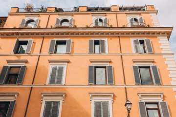 Fototapeta premium Architecture of Rome. A building with the characteristic ocher facade and green windows. Trastevere district