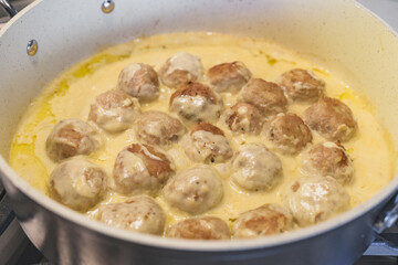 Sweadish meatballs in a creamy white sauce step by step recipe. Meatballs close up on frying pan