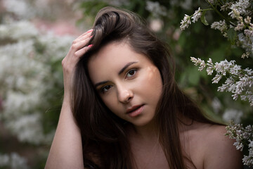  Beauty portrait of a Ukrainian woman posing in front of a lilac tree in bloom. She has brown hair and brown eyes. This photo was taken at the first bloom located in Ottawa, Canada.