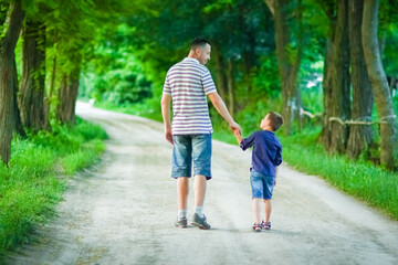 Fototapeta premium A Happy child and parent's hands on nature in the park travel