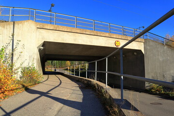 Road for walking and cars under a tunnel. Metal fence. Bålsta, Stockholm, Sweden.