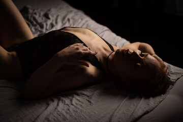 Obraz premium women lying on bed in black lingerie