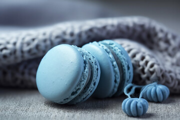 French blue colored macaroons cookie, closeup isolated on blue textile, on grey background. AI Generated.