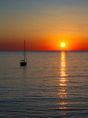 Un bateau sur l'océan au coucher de soleil orange