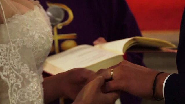 novios entreg&aacute;ndose anillos en su boda 