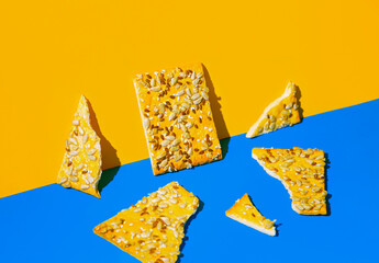 Creative composition made of crunchy cereal cookies closeup on bright blue and orange background. Healthy dessert concept.