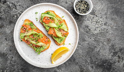 Open sandwiches with salted salmon, guacamole avocado and fresh greens. Delicious breakfast or snack, Clean eating, dieting, vegan food concept. top view.