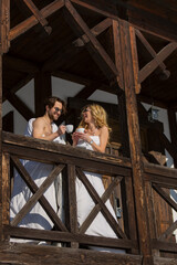 Fototapeta na wymiar couple wrapped in blankets drinking coffee on the balcony