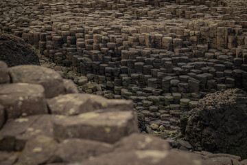 Detail of hexagonal stones or pillars at Giants causeway in northern ireland, majestic basalt pillars at the beach on a cloudy day.