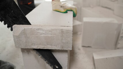 Worker at the construction site. The masonry is built from a lightweight concrete block. Block masonry.
