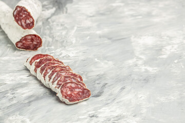 Sausage salami with noble mold cut in slices on a light background. banner, menu, recipe place for text, top view