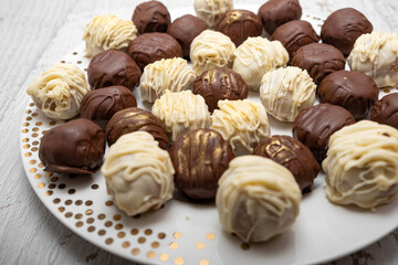 Chocolate truffles on plate on white table. Homemade