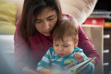 Mother And Baby Son Reading Book Together