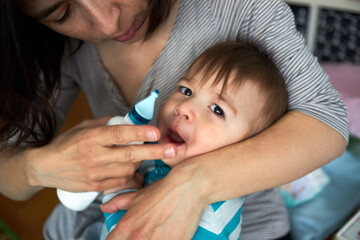Mother nasal washing cleaning baby nose by salt water