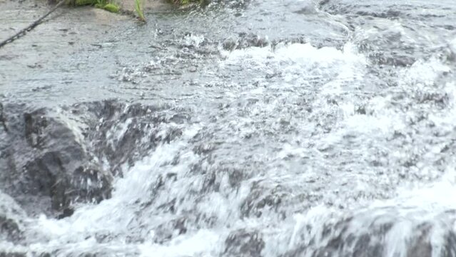 Water cascades and flows over river rocks