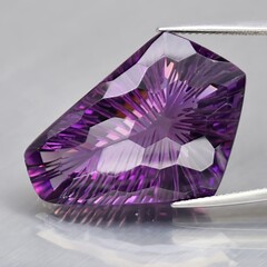 Natural gemstone purple amethyst on gray background