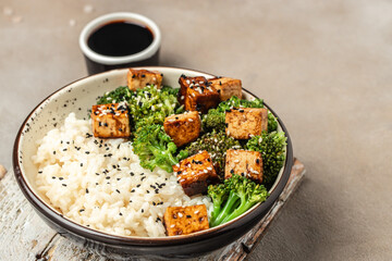 Savory sauteed mixed chinese rice, broccoli with fried tofu, Asian vegan bowl, Long banner format. top view