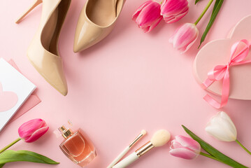 Top view photo of heart shaped giftbox tulips trendy high heel shoes envelope letter cosmetics brushes and perfume on isolated pastel pink background with copyspace in the middle