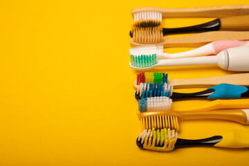 Electric and manual toothbrushes on a yellow background. View from above. Oral hygiene. Ordinary toothbrush, eco and electric toothbrush. Oral hygiene. Oral Care Kit. Dentist concept. Dental care.