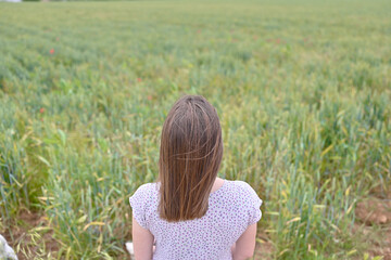 Unrecognizable woman observes a barley field sown in Spain. Relaxing image.