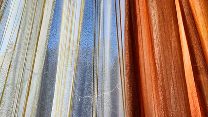 White tulle curtain and other sun curtain hung on window with sun. Abstract background and texture...