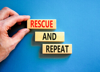 Rescue and repeat symbol. Concept words Rescue and repeat on wooden block on a beautiful blue table...