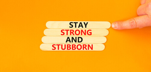 Stay strong and stubborn symbol. Concept words Stay strong and stubborn on wooden stick. Beautiful orange table orange background. Motivational business stay strong and stubborn concept. Copy space.