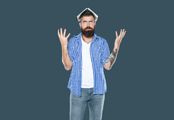 Fototapeta premium irritated bearded man with book on head on grey background