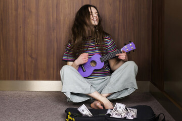 A cute long-haired emotional hippie girl playing an ukulele in an elevator and collecting tips....
