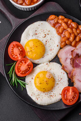 Delicious nutritious English breakfast with fried eggs and tomatoes