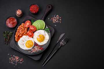 Fototapeta na wymiar Delicious nutritious English breakfast with fried eggs, tomatoes and avocado
