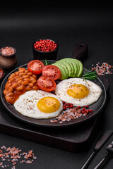 Delicious nutritious English breakfast with fried eggs, tomatoes and avocado
