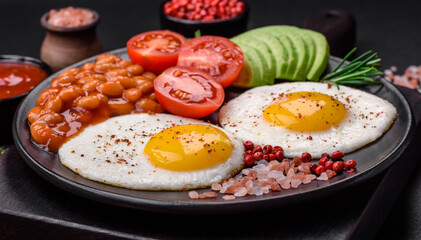 Delicious nutritious English breakfast with fried eggs, tomatoes and avocado