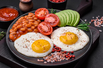 Delicious nutritious English breakfast with fried eggs, tomatoes and avocado