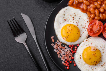 Delicious nutritious English breakfast with fried eggs, tomatoes and avocado
