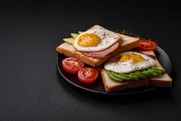 Delicious nutritious English breakfast with fried eggs, tomatoes and avocado