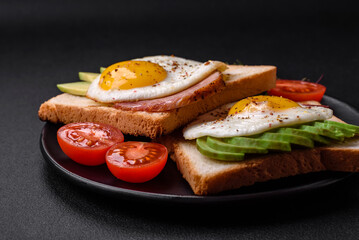 Delicious nutritious English breakfast with fried eggs, tomatoes and avocado
