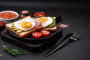 Delicious nutritious English breakfast with fried eggs, tomatoes and avocado