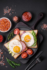 Delicious nutritious English breakfast with fried eggs, tomatoes and avocado