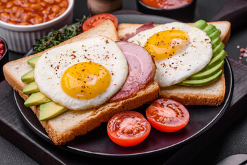 Delicious nutritious English breakfast with fried eggs, tomatoes and avocado