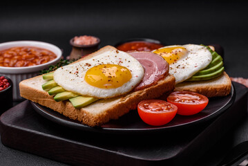 Delicious nutritious English breakfast with fried eggs, tomatoes and avocado