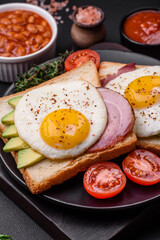 Delicious nutritious English breakfast with fried eggs, tomatoes and avocado