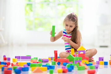 Child playing with toy blocks. Toys for kids.