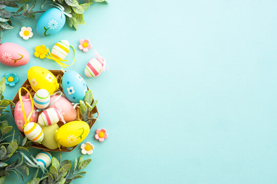 Easter eggs in the nest on blue background. Easter decor. Flat lay image with copy space.