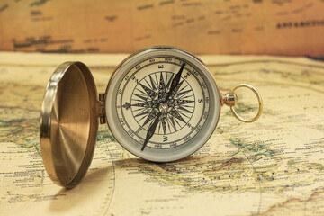 Classic round compass on background of old vintage map